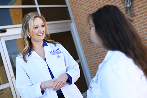 Two women conversing in lab coats